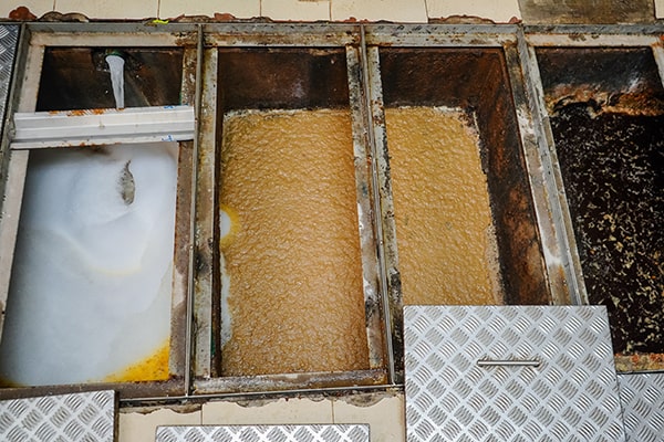 grease trap maintenance involves emptying and cleaning the trap, as well as inspecting for any issues or damage